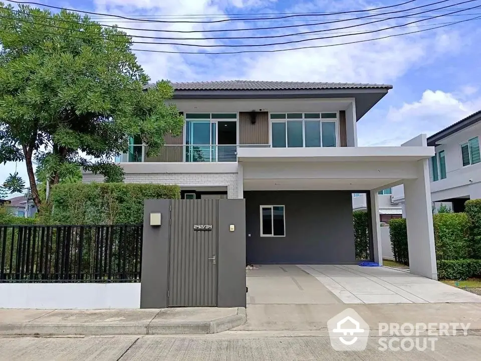 Modern two-story house with spacious driveway and lush greenery in a serene neighborhood.