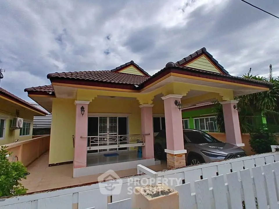 Charming single-story house with a tiled roof and spacious carport in a serene neighborhood.