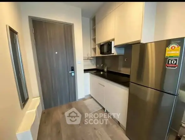 Modern kitchen with sleek cabinets and stainless steel appliances in compact layout.