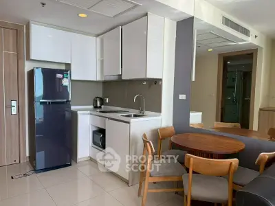 Modern kitchen with sleek cabinets, compact dining area, and contemporary appliances in a stylish apartment.