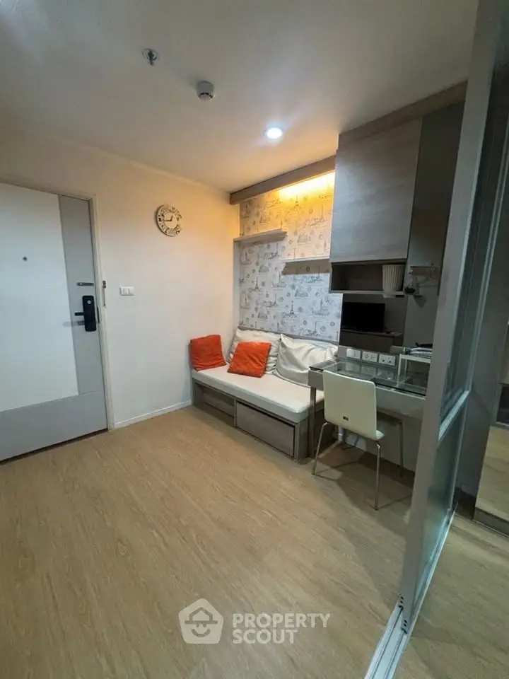 Cozy living room with modern decor and wooden flooring, featuring a stylish sofa and wall-mounted shelves.
