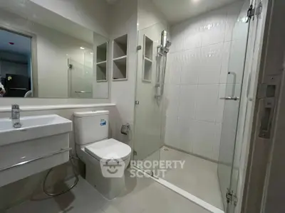 Modern bathroom with glass shower and sleek fixtures in a contemporary apartment.