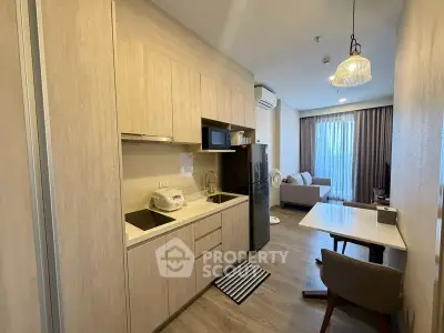 Modern apartment interior with open kitchen and cozy living area, featuring stylish furniture and natural lighting.