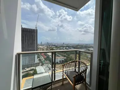 Stunning city view from a modern high-rise balcony with stylish outdoor seating.