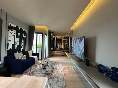 Luxurious modern living room with sleek design and large TV, featuring stylish decor and ample natural light.