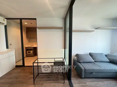 Modern living room with glass partition and stylish furniture in a contemporary apartment.