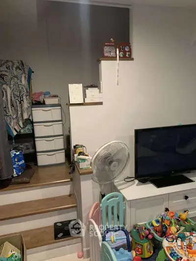 Cozy living space with TV, fan, and children's play area