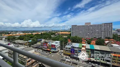 Stunning cityscape view from a high-rise balcony with vibrant skyline and lush greenery.