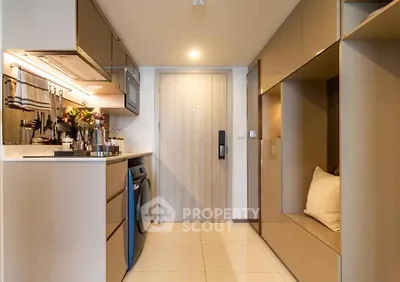 Modern kitchen with sleek cabinetry and integrated washing machine in compact apartment.