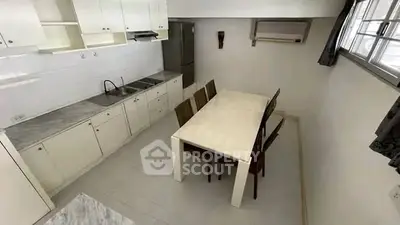 Spacious kitchen with dining area and modern appliances in a bright, airy setting.