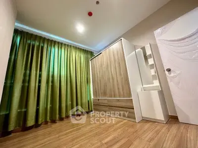 Spacious bedroom with modern wardrobe and elegant green curtains