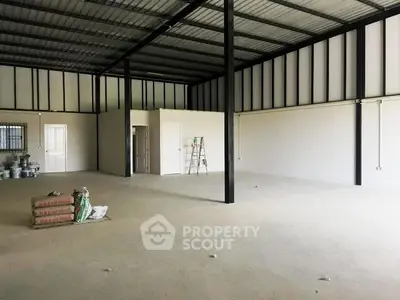 Spacious industrial warehouse interior with high ceilings and ample open space.