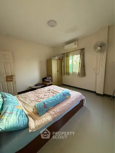 Cozy bedroom with natural light and air conditioning, perfect for relaxation.
