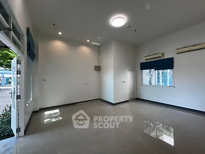 Spacious unfurnished room with large windows and air conditioning units, ideal for customization.