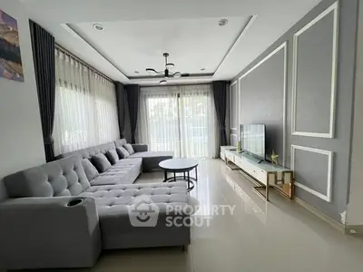 Spacious modern living room with elegant gray sofa and large windows.