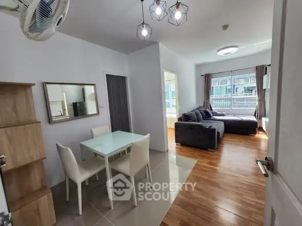 Modern apartment interior with dining area and cozy living room featuring stylish decor and ample natural light.