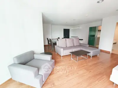 Spacious modern living room with stylish gray furniture and wooden flooring