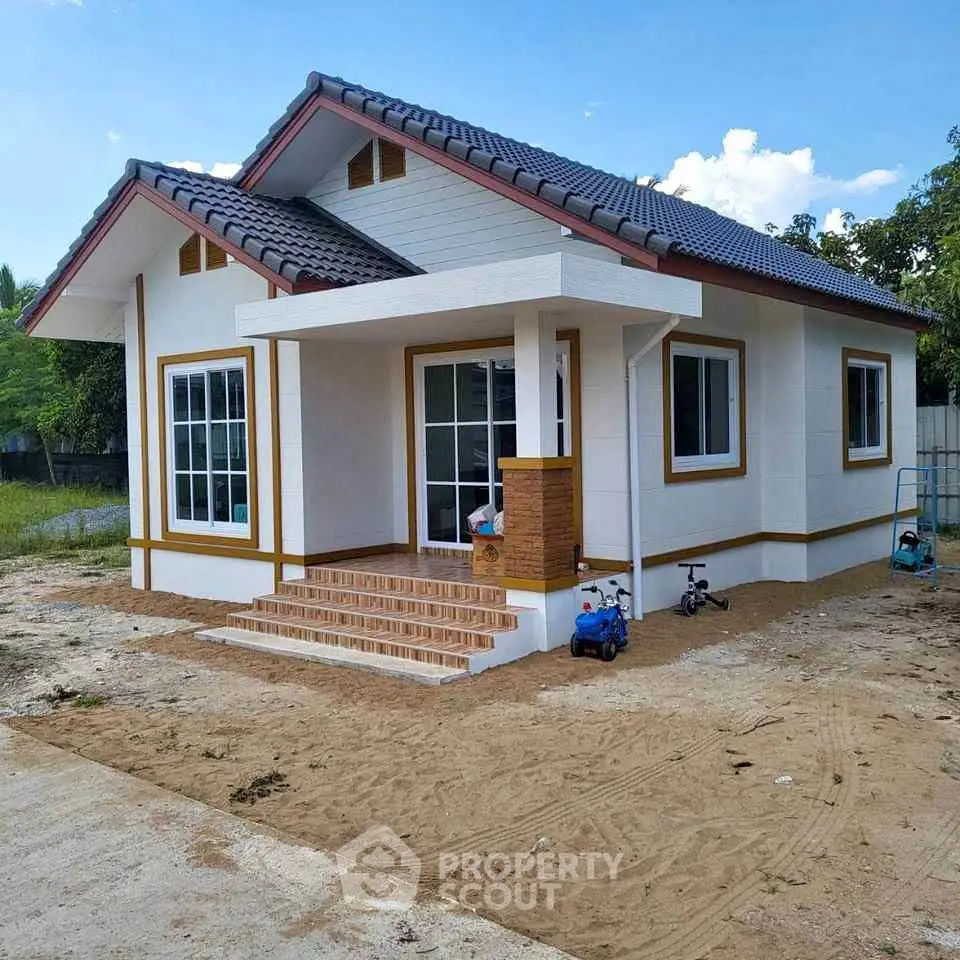 Charming single-story house with tiled roof and spacious front yard.