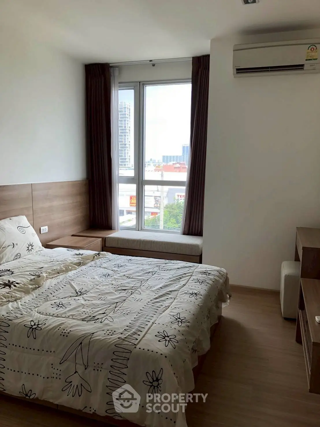 Modern bedroom with large window and air conditioning, offering city views.