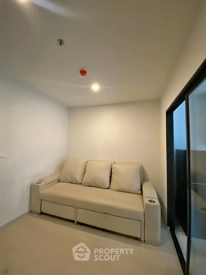 Cozy small living room with beige sofa and modern sliding glass door