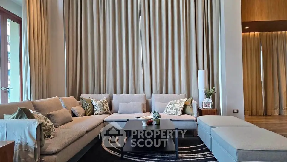 Luxurious living room with elegant decor and large windows, perfect for relaxation and entertaining.
