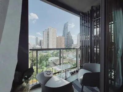 Modern balcony with stunning cityscape view and cozy seating area.