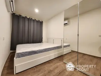 Modern bedroom with mirrored wardrobe and air conditioning in stylish apartment