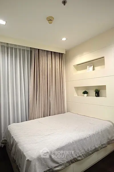 Modern bedroom with elegant design and cozy ambiance, featuring built-in shelves and soft lighting.