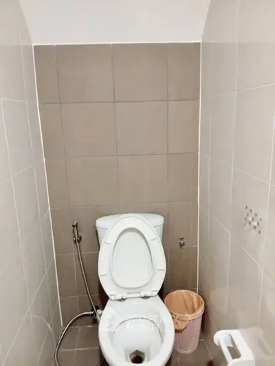 Compact bathroom with modern toilet and tiled walls, perfect for small spaces.