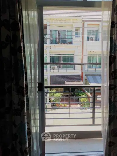 Charming balcony view of modern residential building with lush greenery.