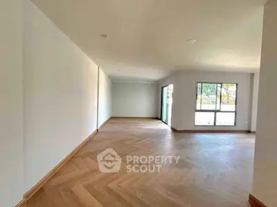 Spacious empty living room with large windows and wooden flooring