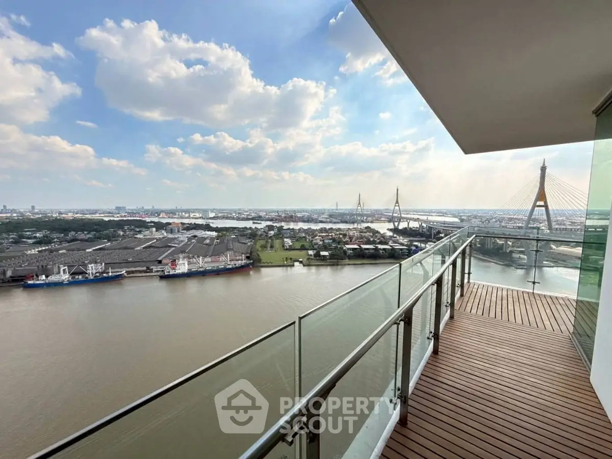 Stunning river view from a spacious balcony in a high-rise apartment, perfect for relaxation and enjoying sunsets.