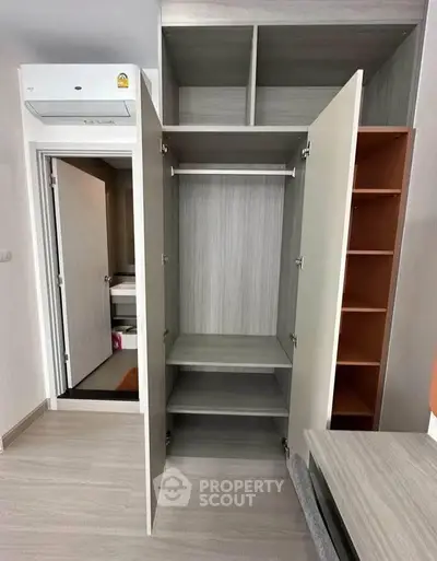 Modern apartment interior with open wardrobe and air conditioning unit