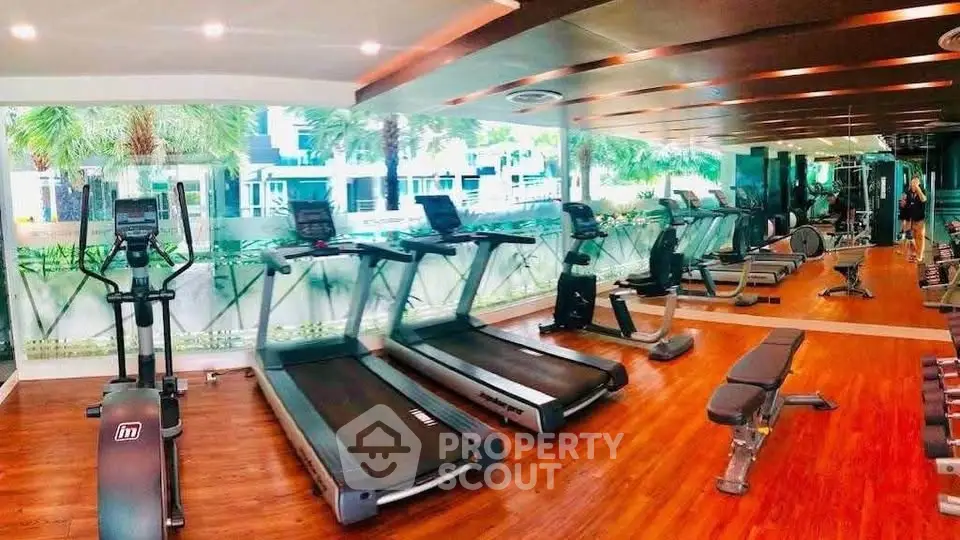 Spacious modern gym with state-of-the-art equipment and lush garden views.