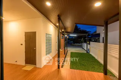 Modern home exterior with wooden ceiling and cozy lighting