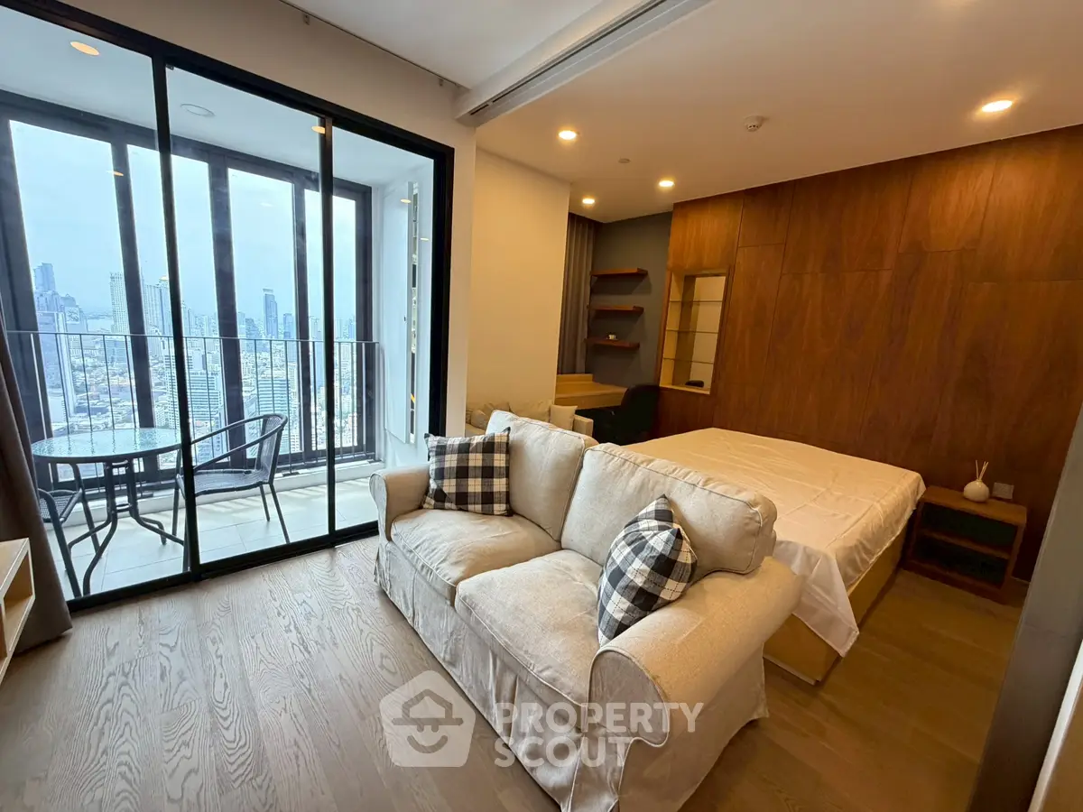 Modern studio apartment with balcony and city view, featuring cozy living area and stylish decor.