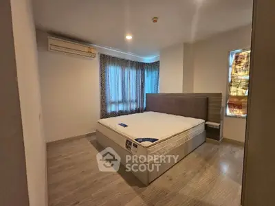 Spacious bedroom with modern design and natural light, featuring a comfortable bed and stylish curtains.