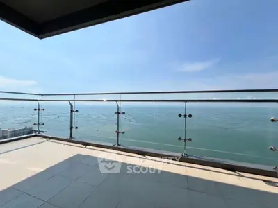 Stunning balcony with glass railing offering breathtaking ocean views, perfect for relaxation.