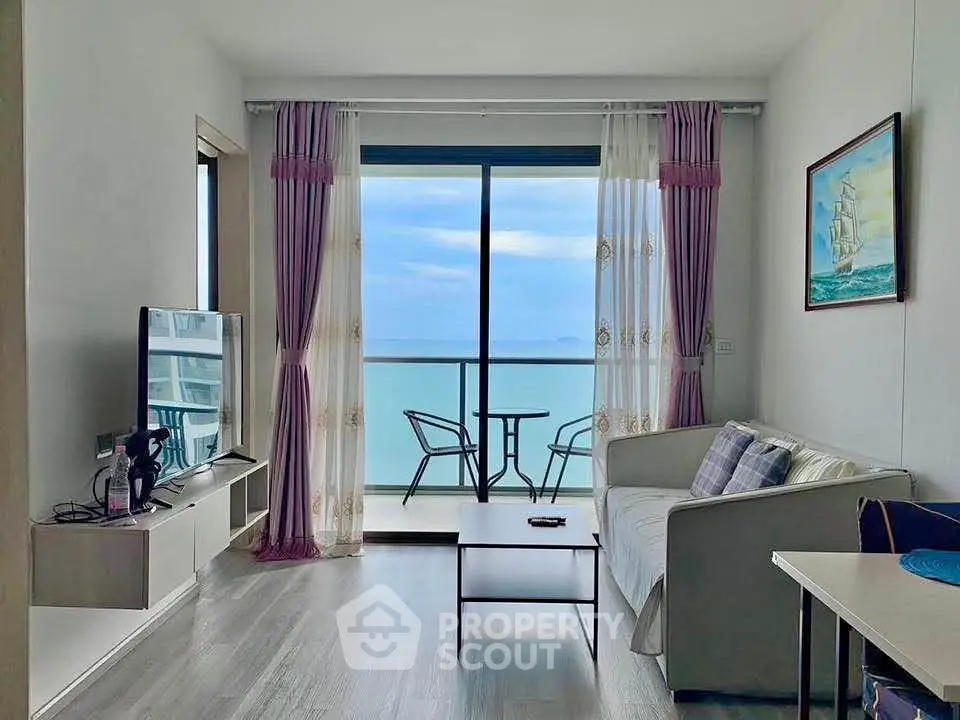 Stunning living room with ocean view, modern decor, and balcony access for ultimate relaxation.