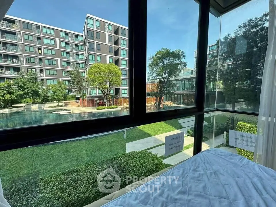Stunning condo view with lush garden and pool, perfect for serene living.
