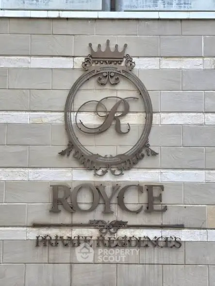 Elegant exterior wall of Royce Private Residences with stylish emblem.