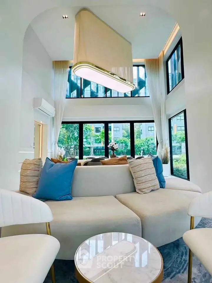 Luxurious modern living room with high ceilings and large windows