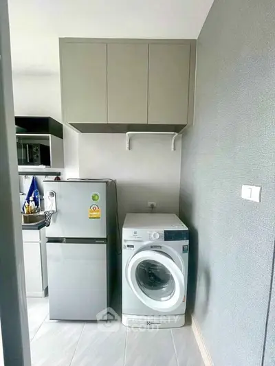 Modern kitchen with washing machine and fridge in compact layout