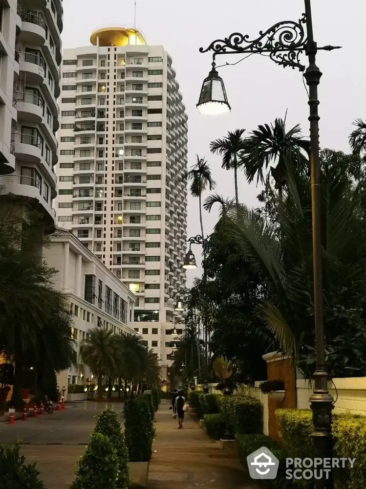 Stunning high-rise building with lush greenery and elegant street lamps in a serene urban setting.