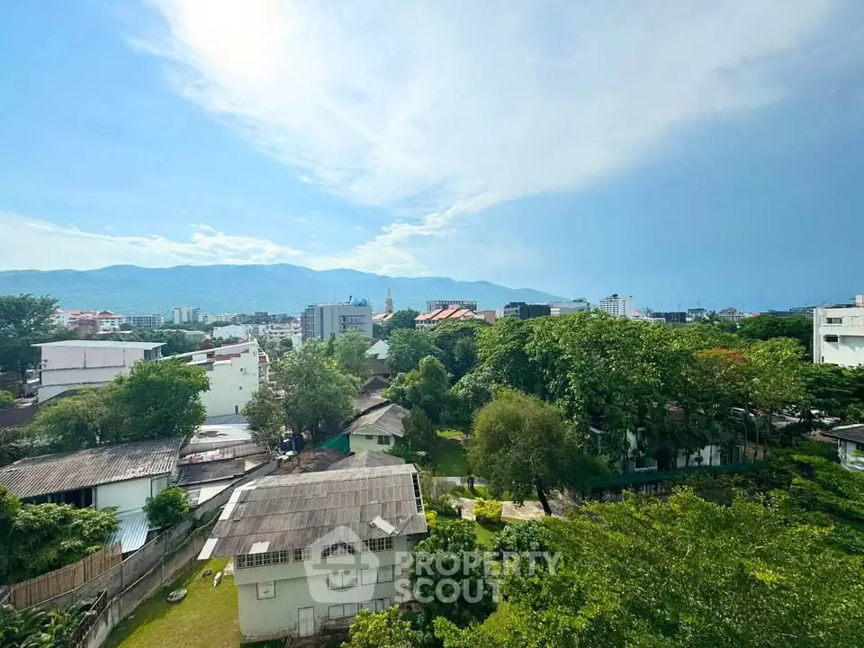 Stunning cityscape view with lush greenery and mountains in the background, perfect for serene living.