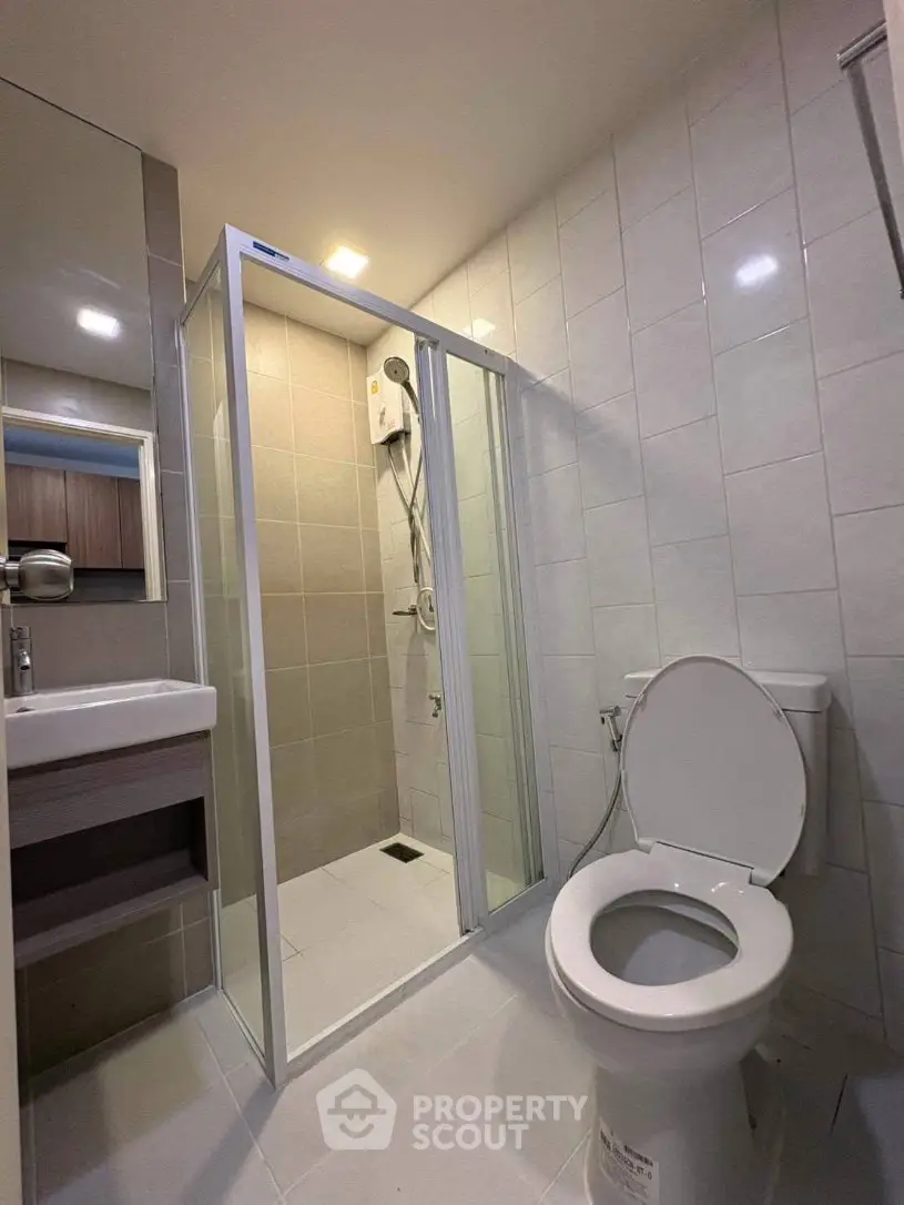 Modern bathroom with glass shower enclosure and sleek fixtures