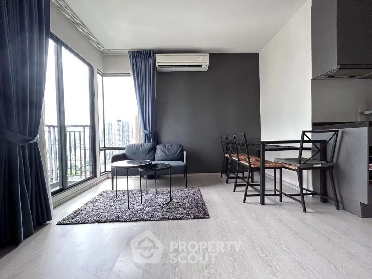 Modern living room with city view, sleek furniture, and large windows.