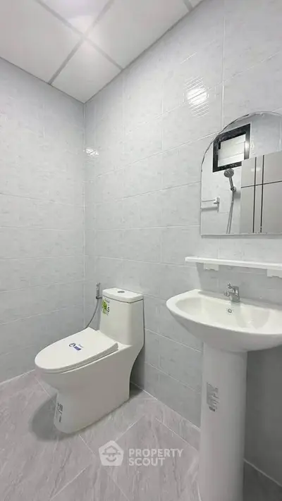 Modern minimalist bathroom with sleek fixtures and tiled walls, perfect for contemporary living.