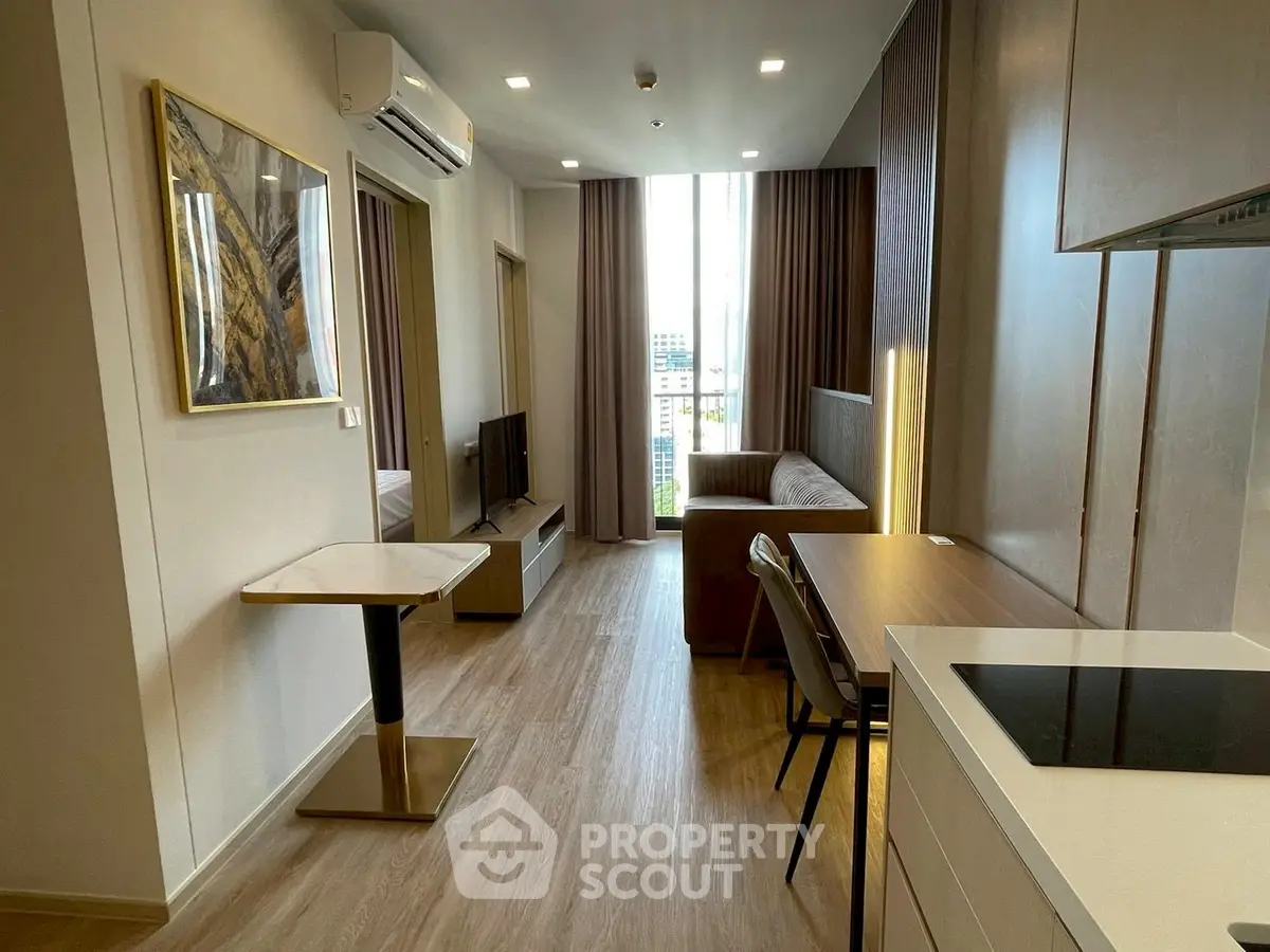 Modern apartment interior with open layout and stylish furnishings, featuring a cozy living area and compact kitchen.