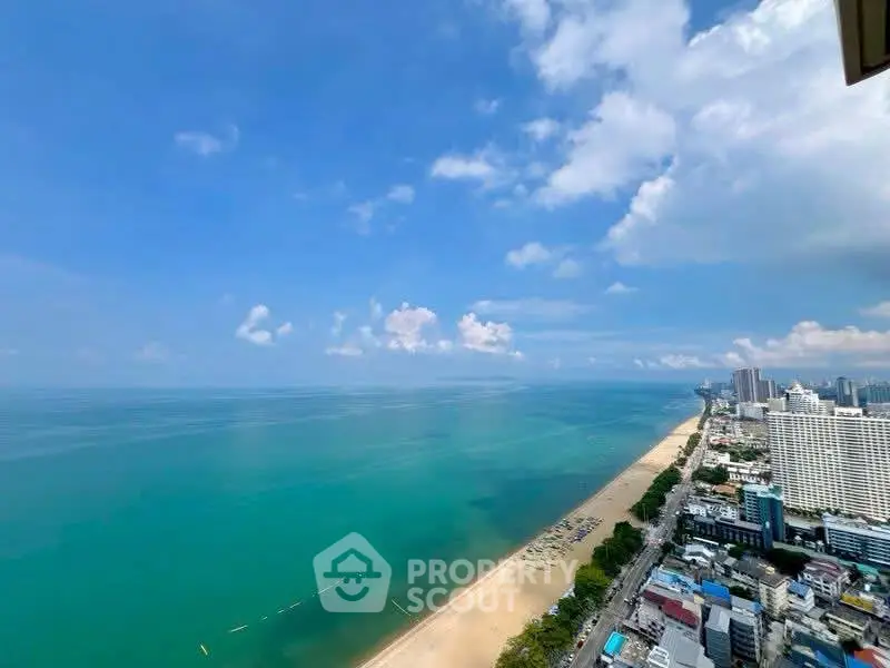 Stunning beachfront view from high-rise apartment overlooking city skyline and ocean.